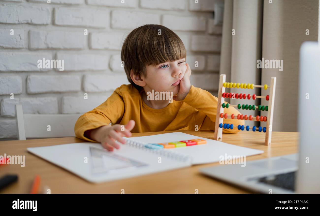 Front view child with abacus learning from laptop home Stock Photo