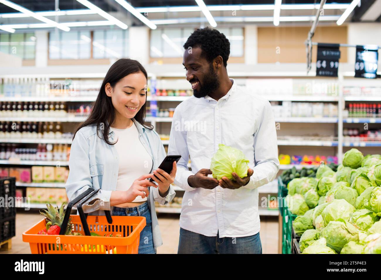 Happy multiethnical couple choosing goods supermarket Stock Photo