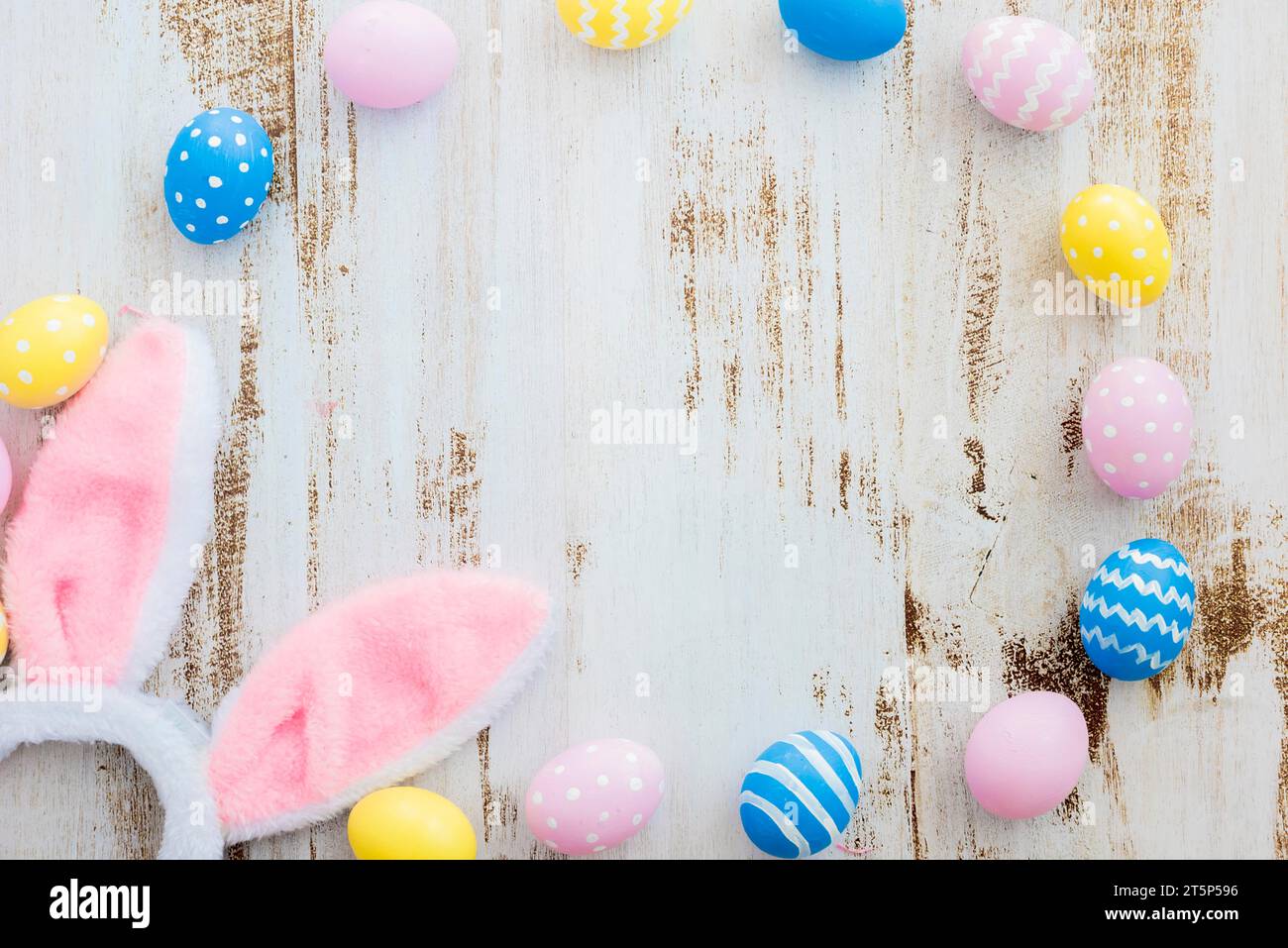 Many easter eggs with bunny ears wooden table Stock Photo
