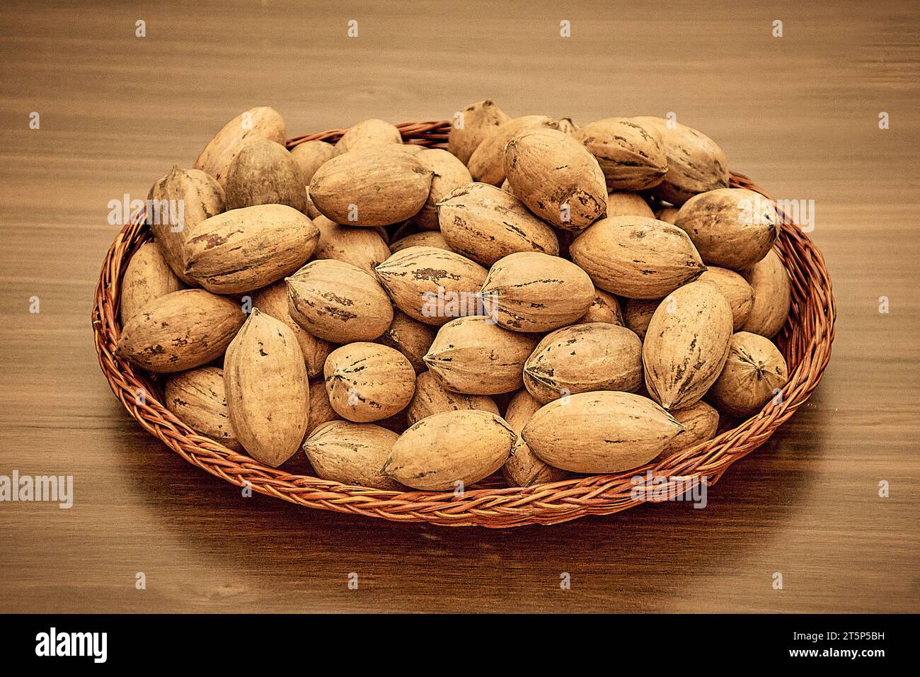 Pecans on the table in a wicker basket. Stock Photo