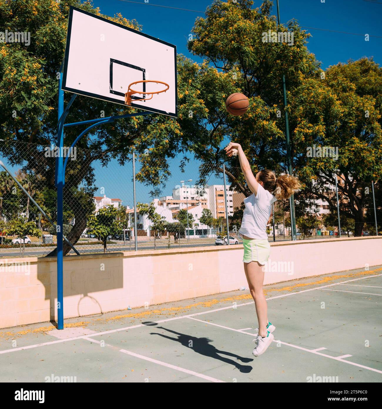 Teen girl playing basketball pitch Stock Photo