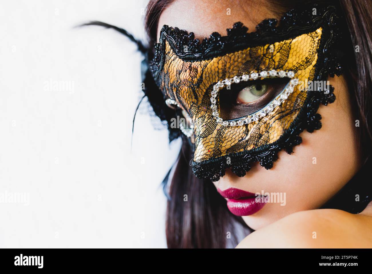 Woman with golden mask black hat white background Stock Photo