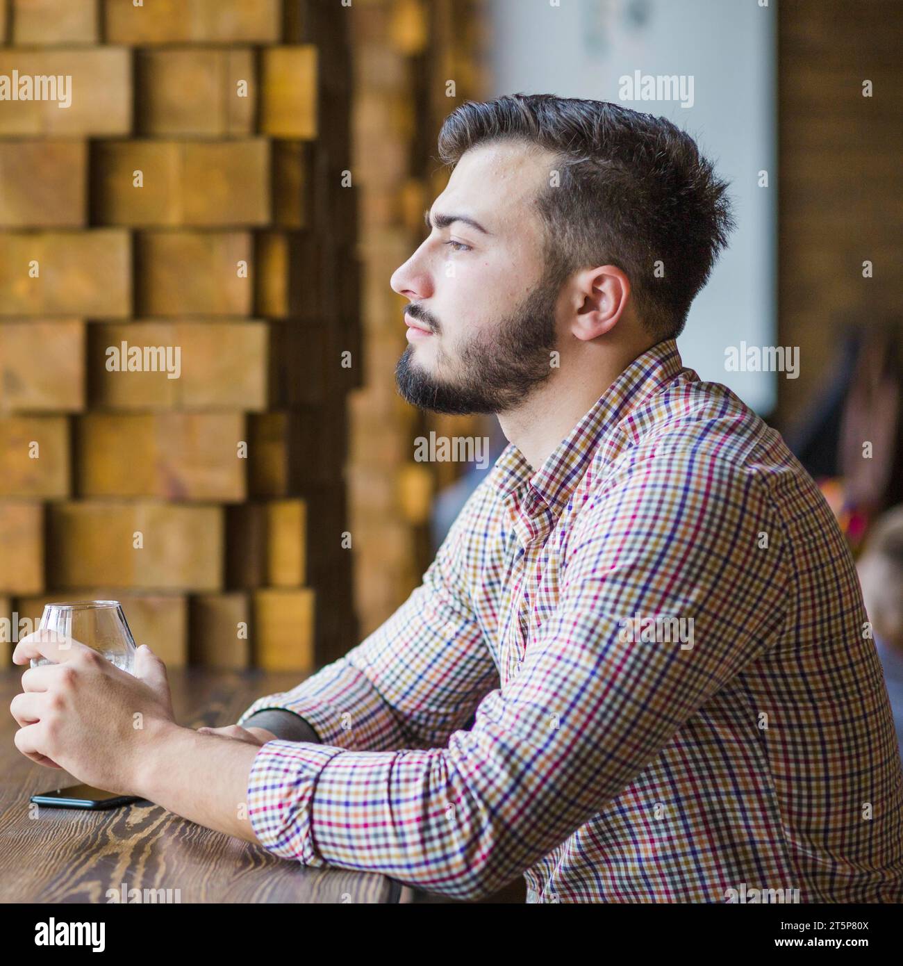 Contemplated young man holding wineglass Stock Photo