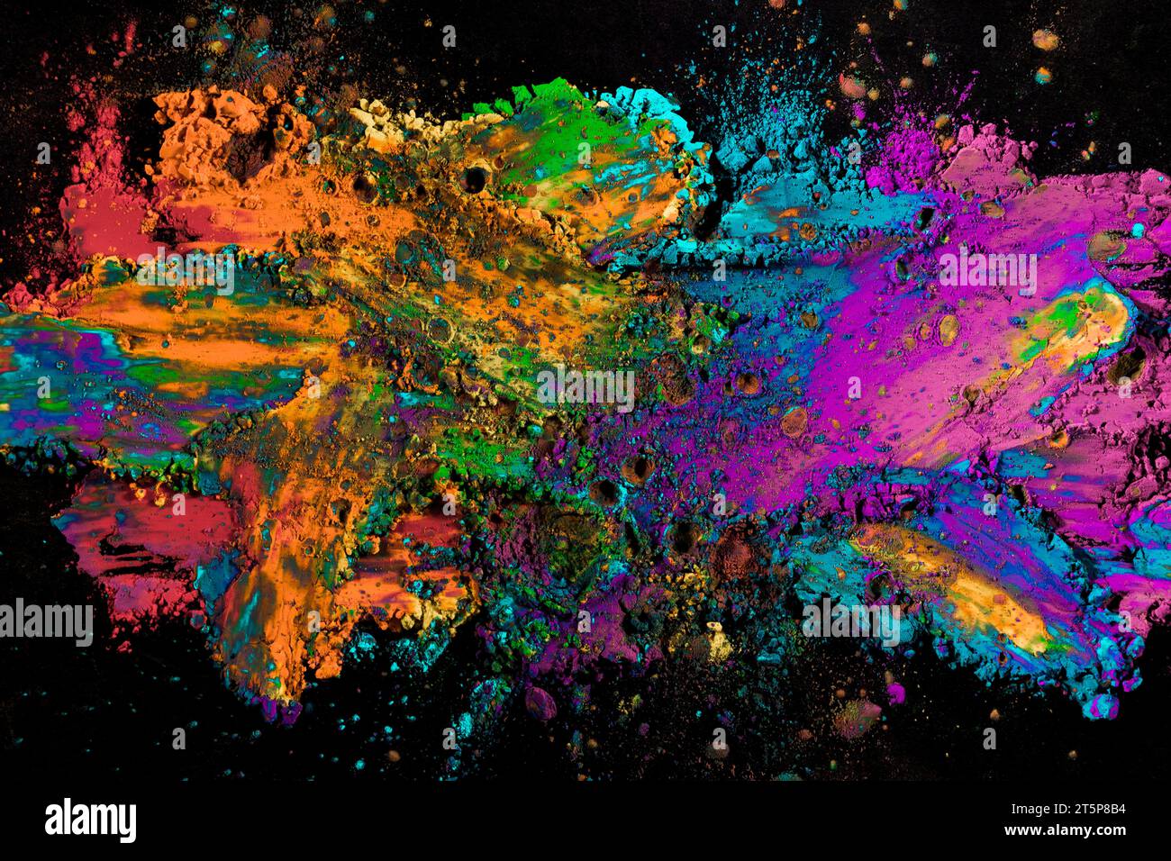 Explosion colored powder black surface Stock Photo