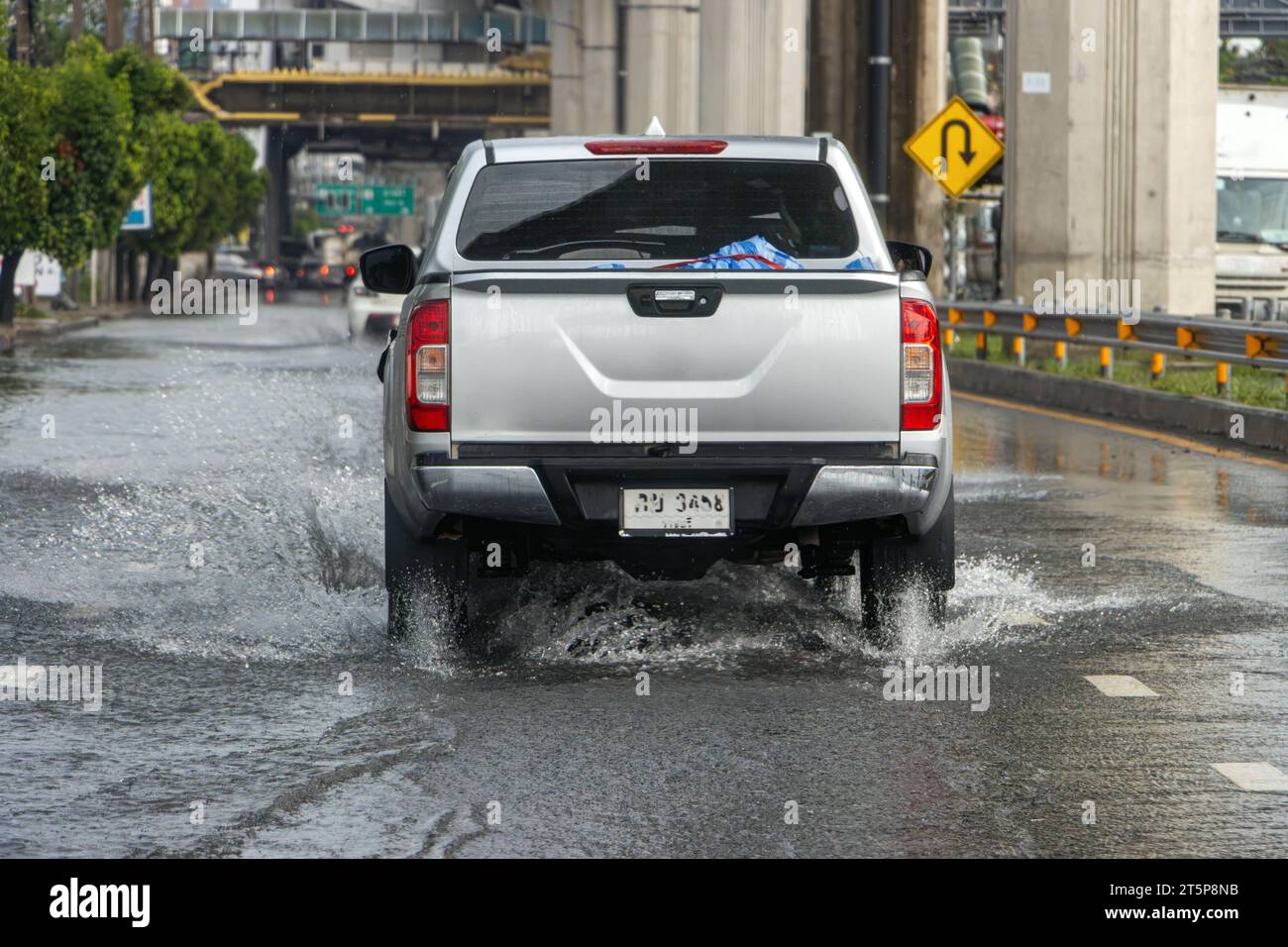 A pick up truck rides on a flooded highway in Bangkok, Thailand Stock Photo