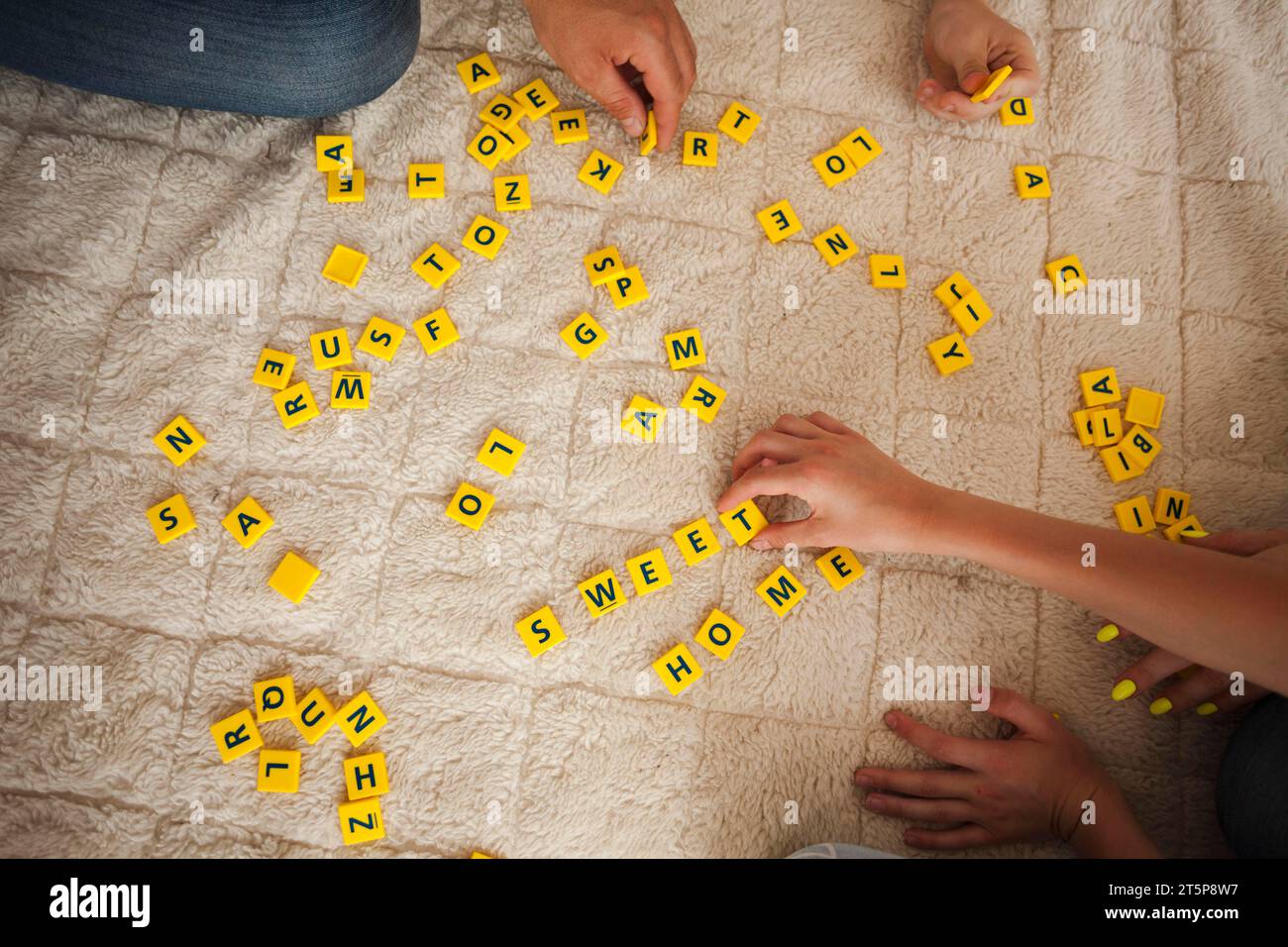 High angle view hand playing scrabble game carpet Stock Photo