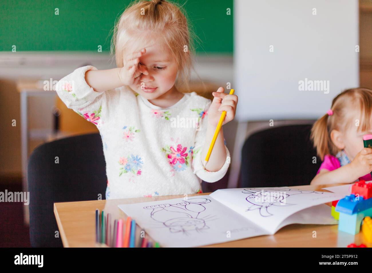 Little girl with pencil painting coloring book Stock Photo