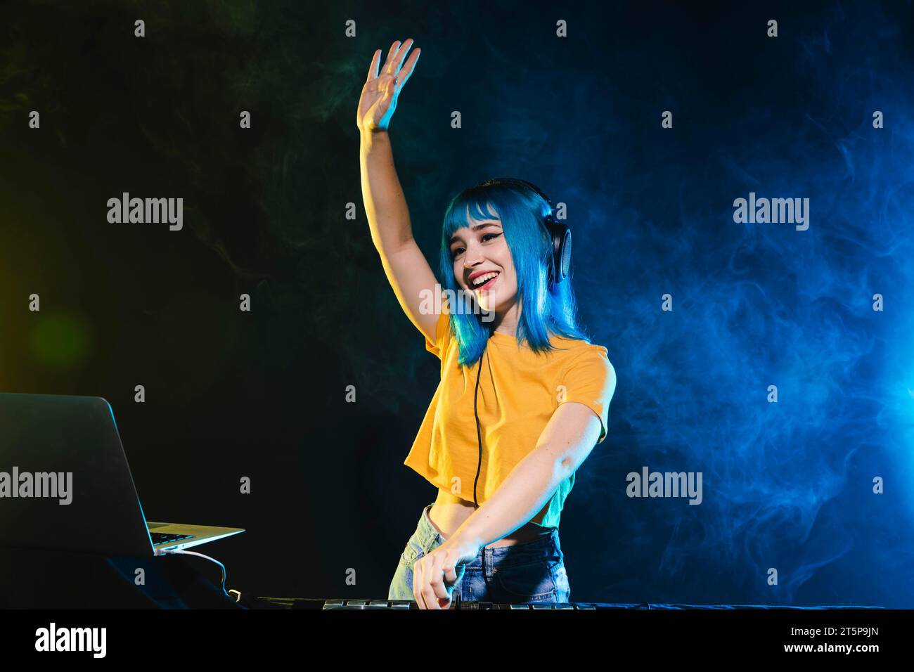 Smiley young female dj mixing Stock Photo