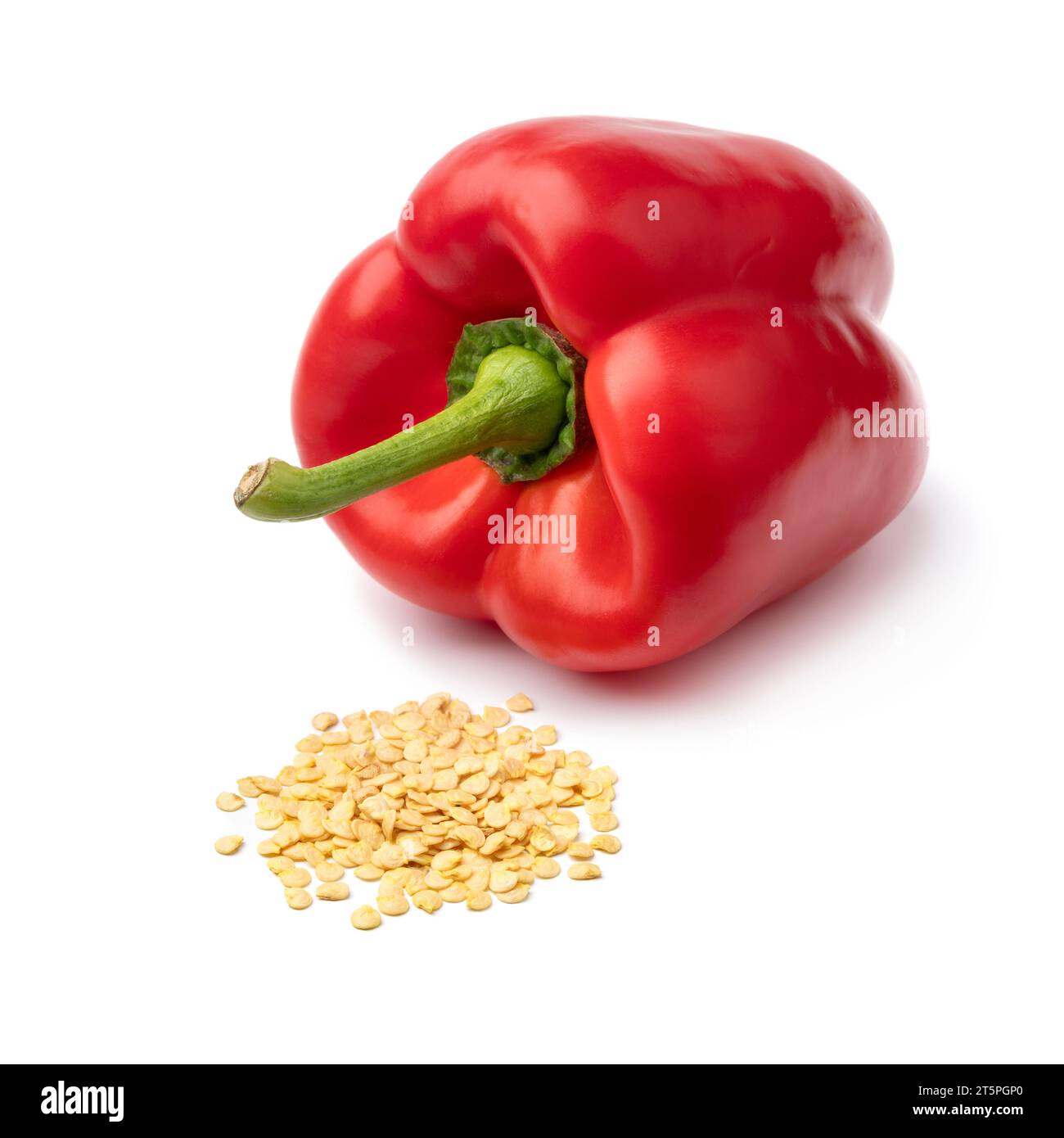 Fresh red bell pepper and a heap of seed in front isolated on white background close up Stock Photo