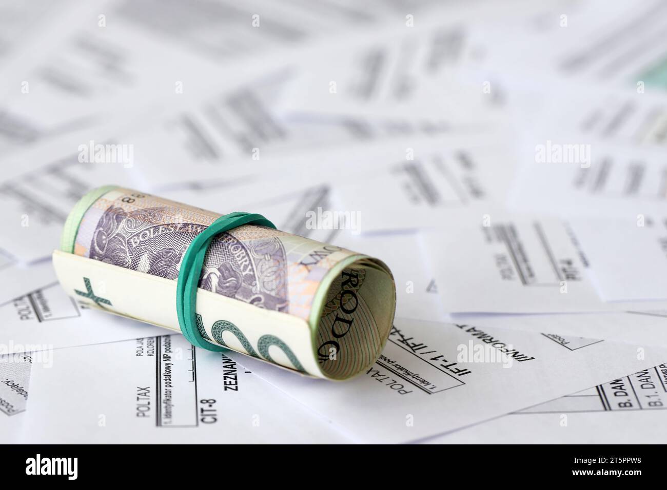 Polish zloty money PLN on big amount of polish PIT, CIT and VAT tax forms close up. Accounting