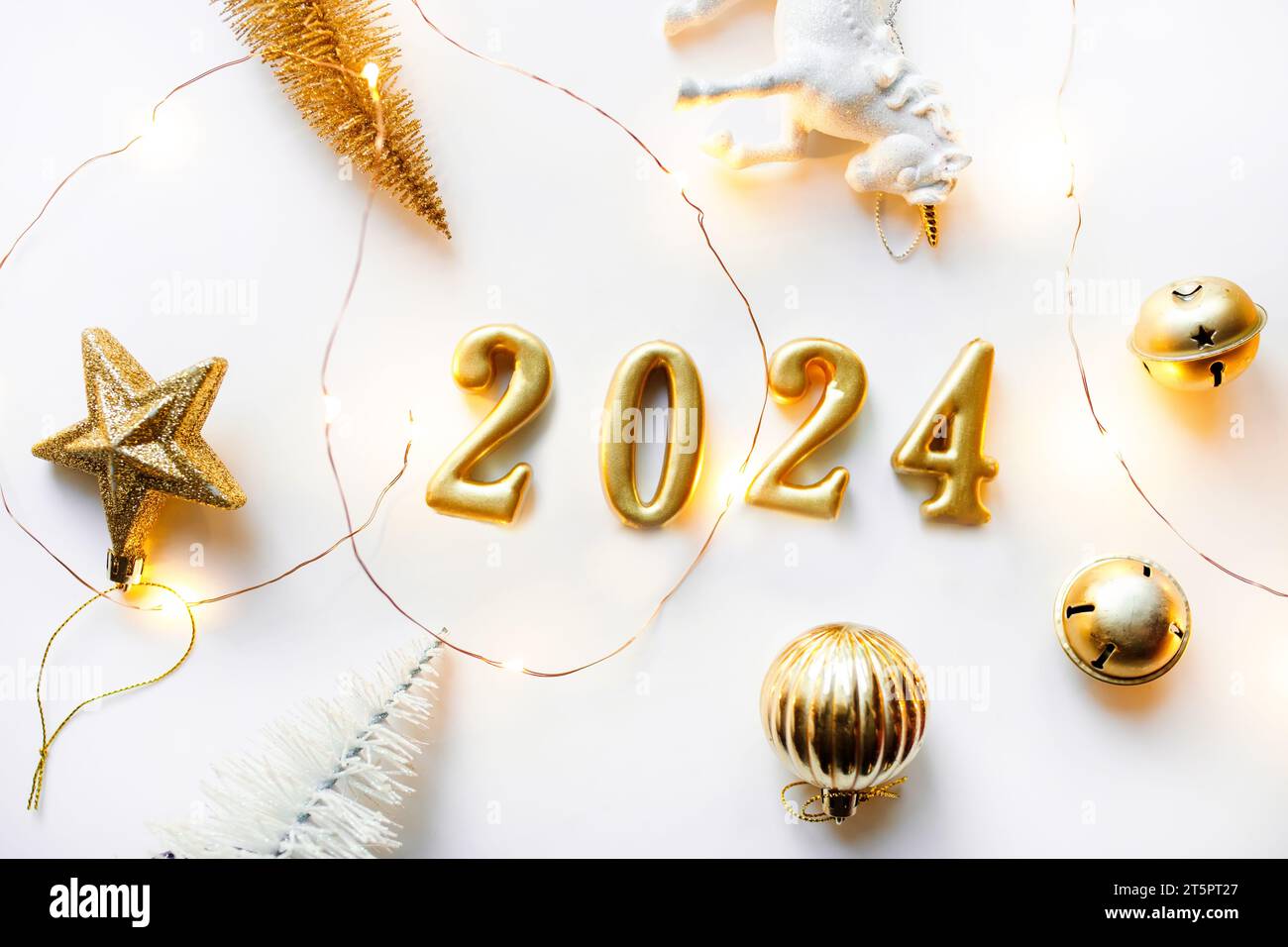 Holiday background Happy New Year 2024. Figures 2024 on a white background with Christmas decorations, balls and a unicorn. Stock Photo