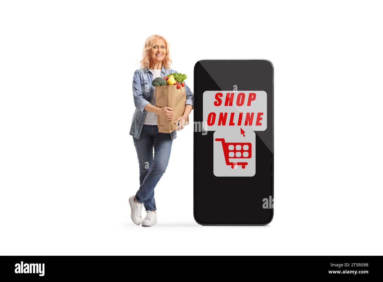 Happy woman with a grocery bag leaning on a big mobile phone with online shopping app isolated on white background Stock Photo