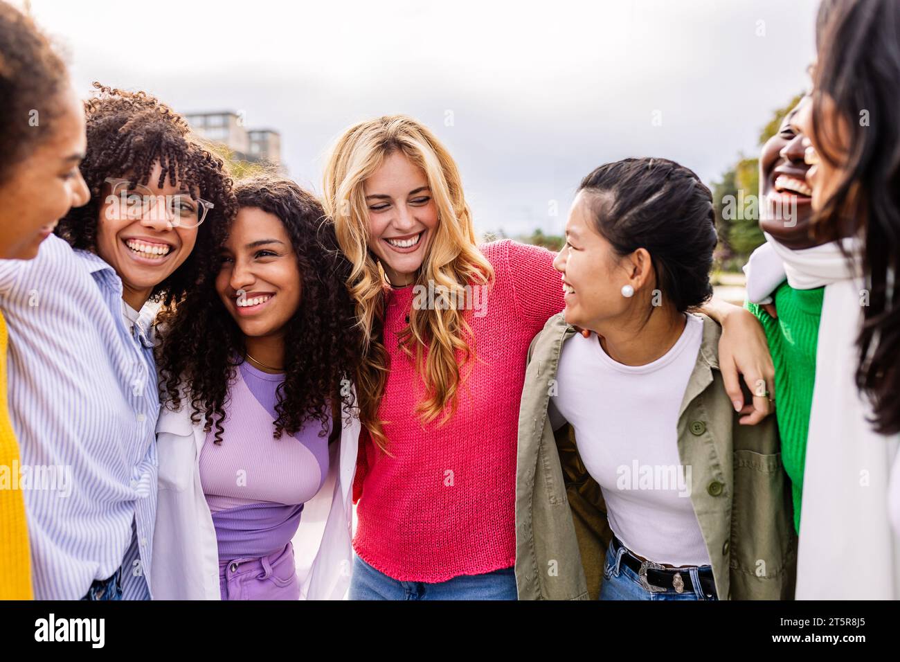 Young group of diverse happy girls laughing together at city street ...
