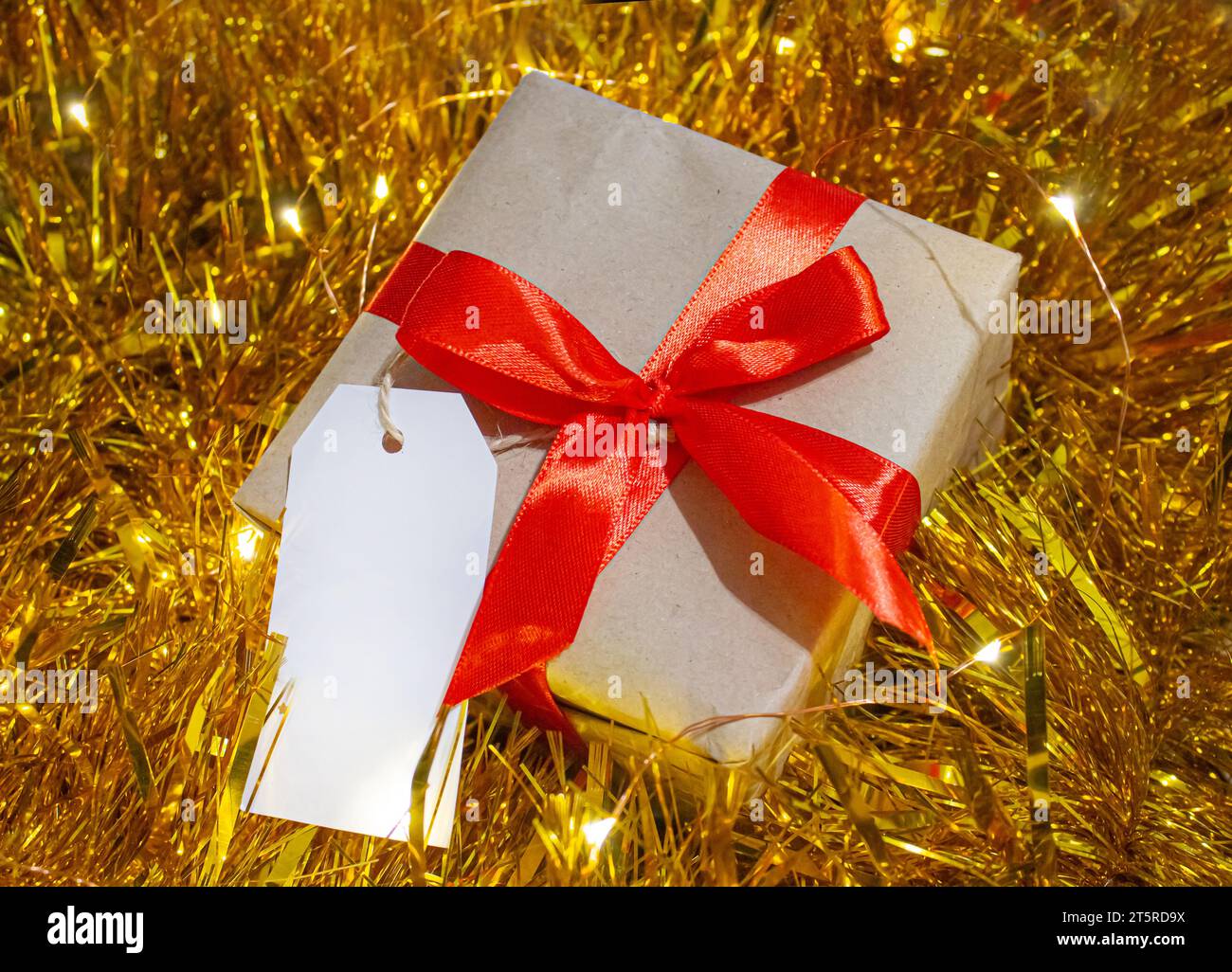 Gift box Wrapped with Kraft paper and Red bow in gold Christmas Garland ...