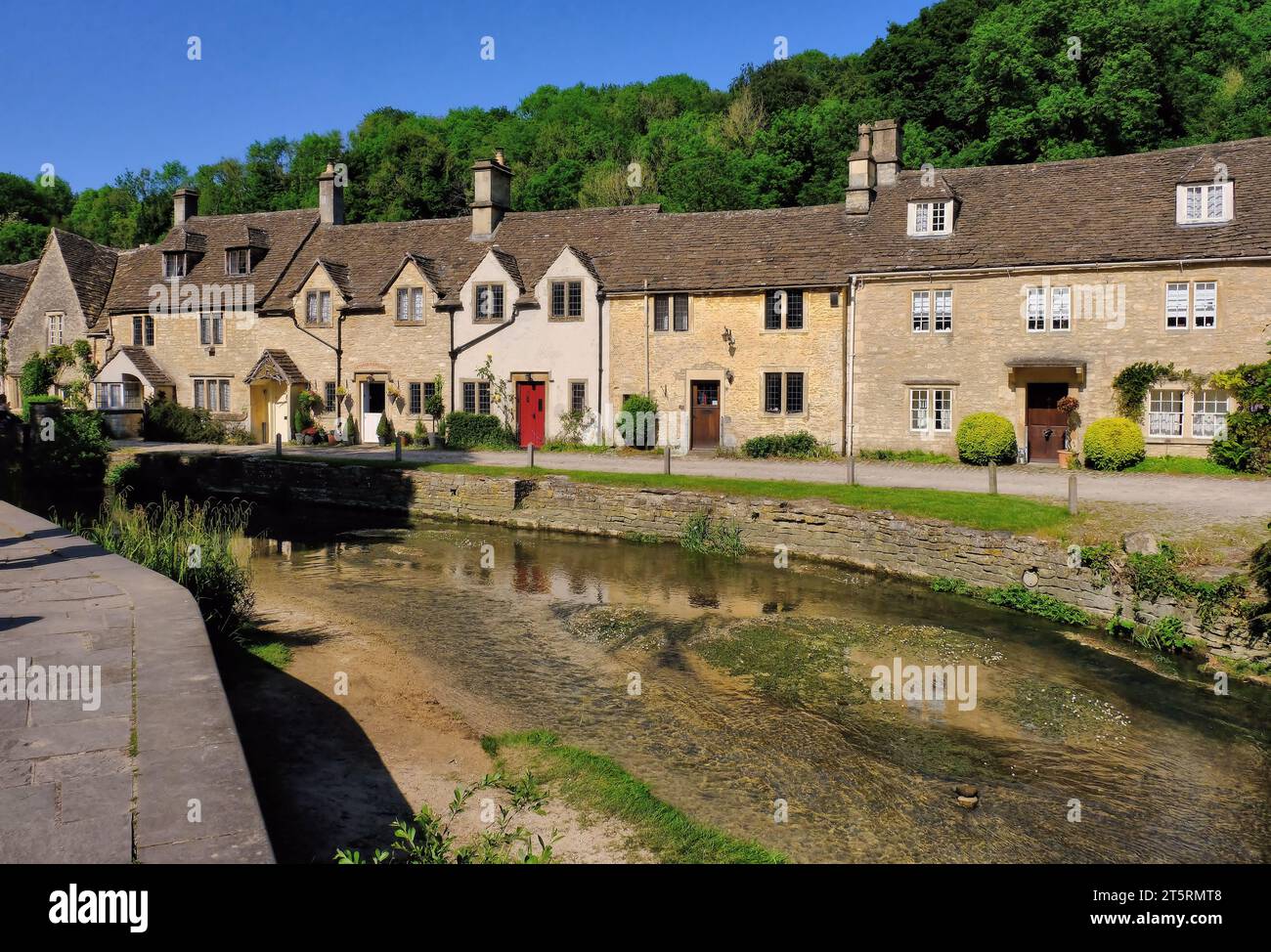 Castle Combe: Cotswold stone cottages in Water Lane and reflections in By Brook at Castle Combe village, Cotswolds, Wiltshire, England, UK Stock Photo