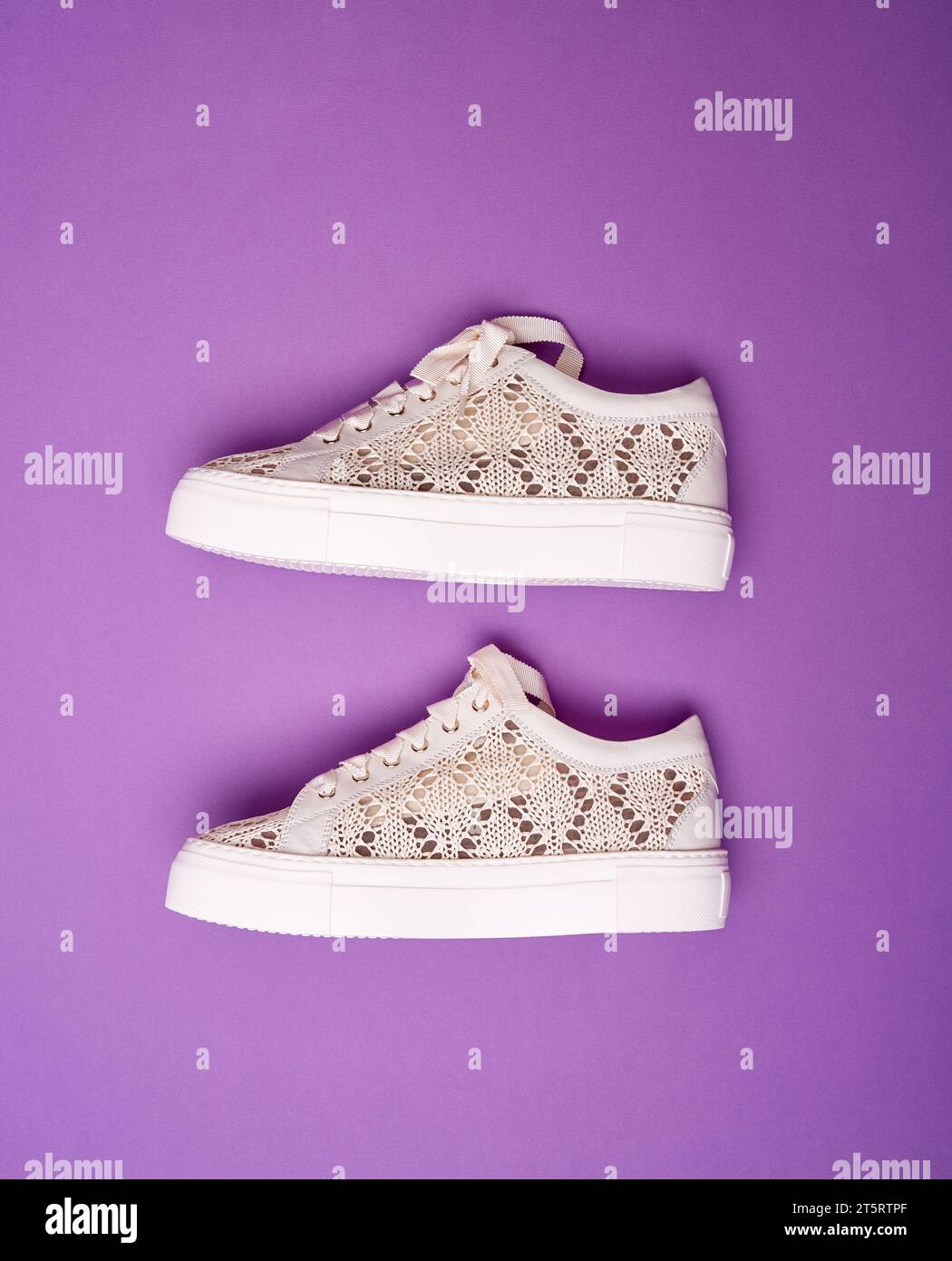 https://c8.alamy.com/comp/2T5RTPF/trendy-beige-knitted-design-sneakers-with-white-thick-rubber-soles-on-a-bright-purple-background-shoe-sale-clearance-ad-concept-2T5RTPF.jpg