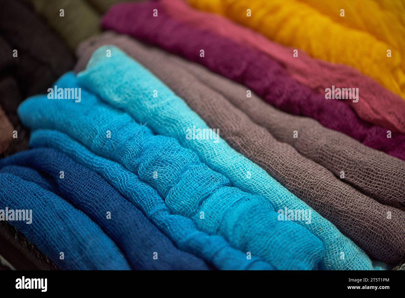 A stack of bright gauze fabrics of different colors. Fabric texture