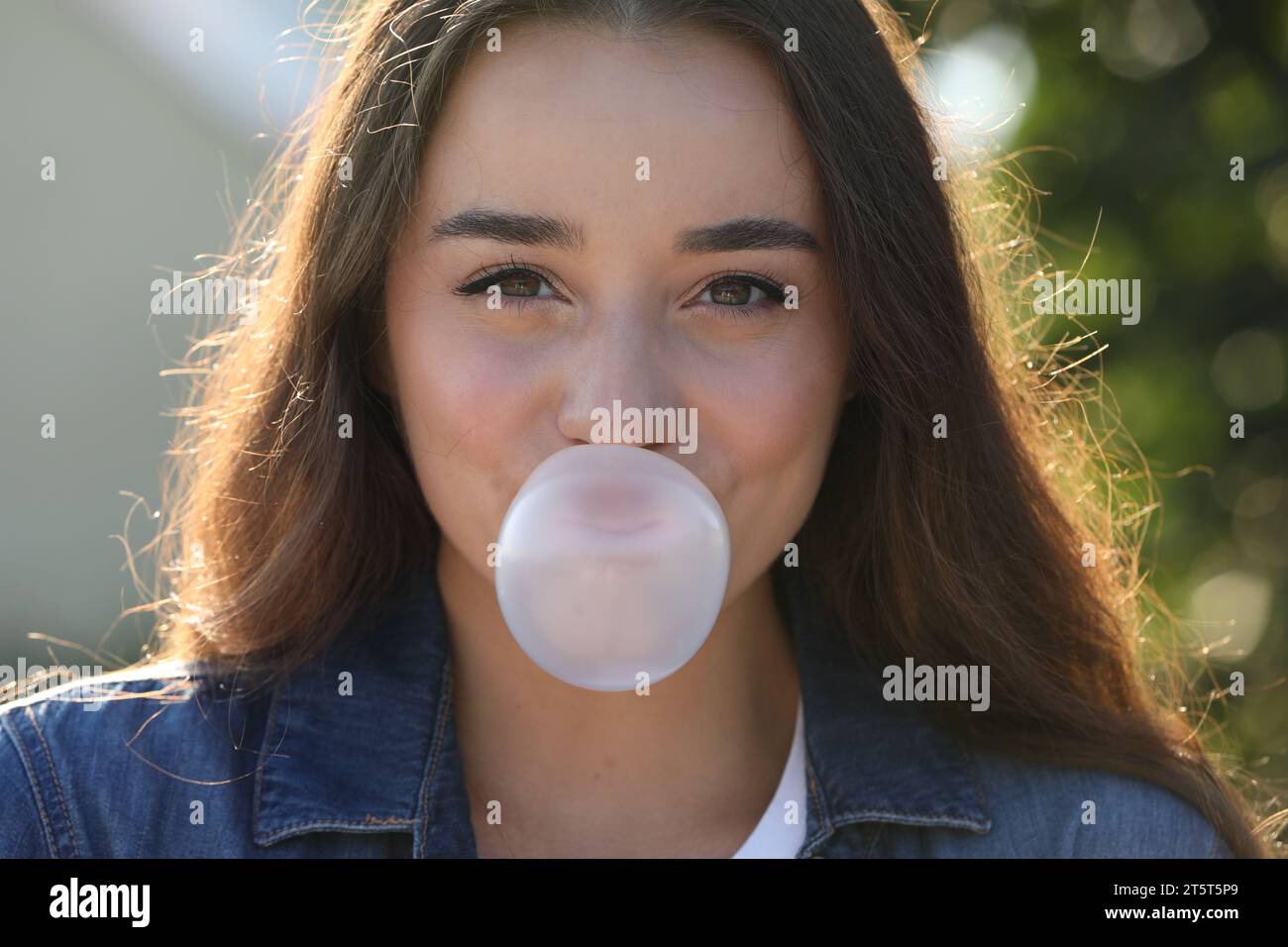 Beautiful young woman blowing bubble gum