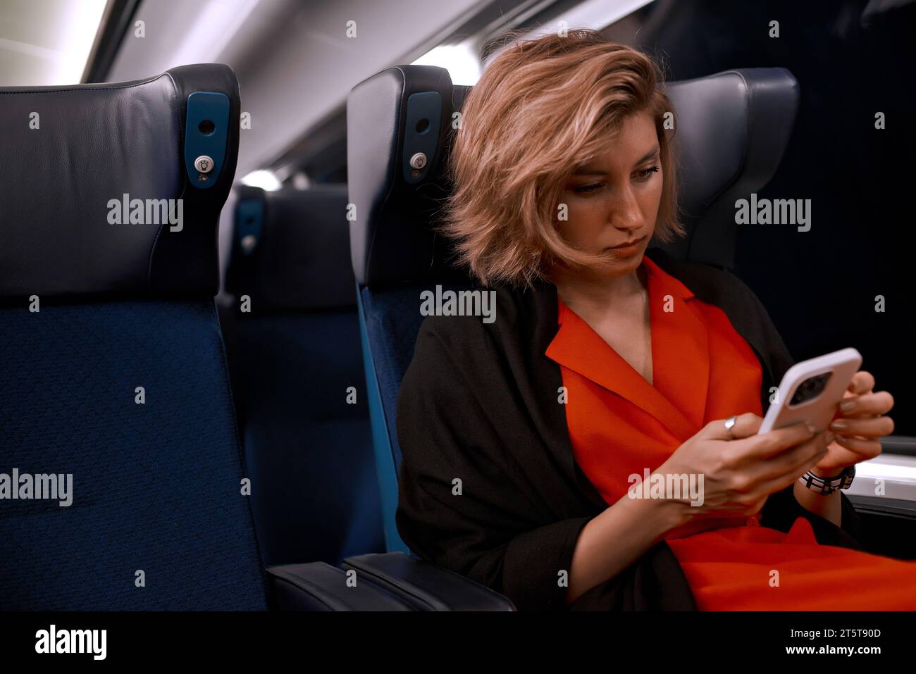 Public transport with woman in train on commute into city or work during evening time. Public transportation reading social media, online news or city Stock Photo