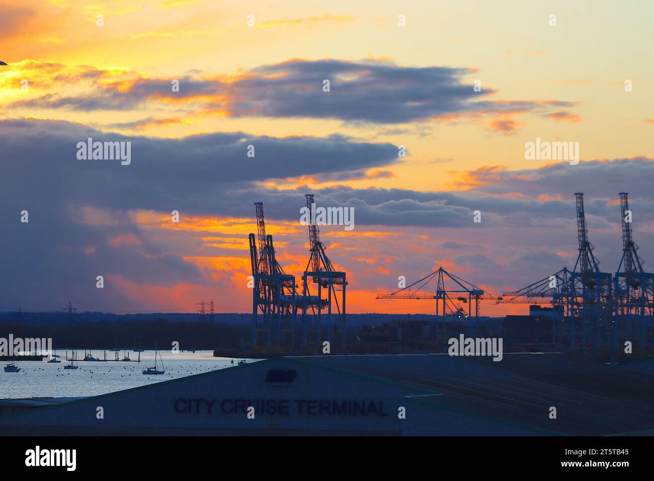 Wintery showers peter out to revealing a flaming sunset over the River Test and container terminal at Southampton, Hampshire, April 2022. Stock Photo