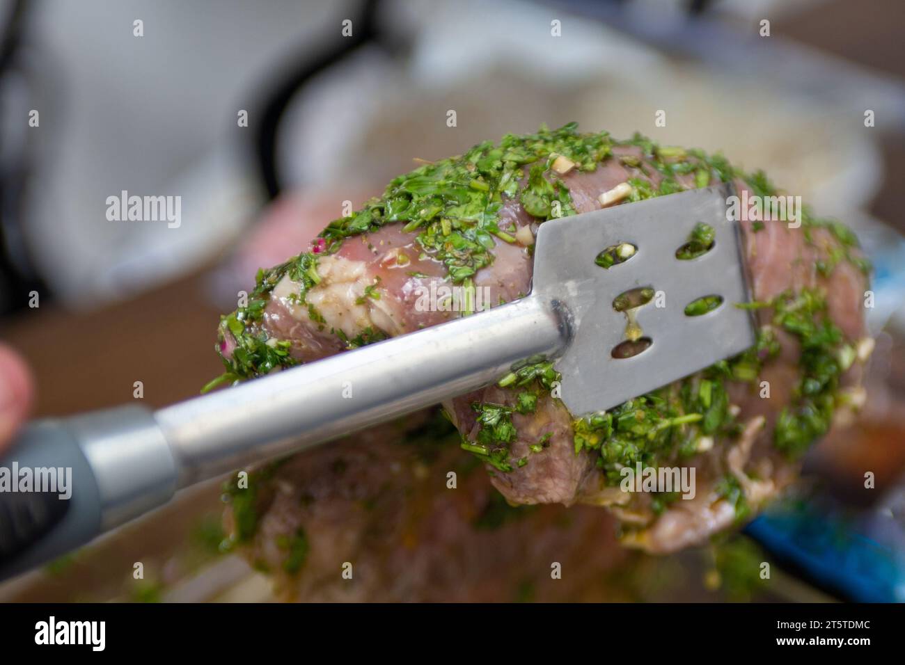 Grabbing marinated steak to be thrown on the grill Stock Photo