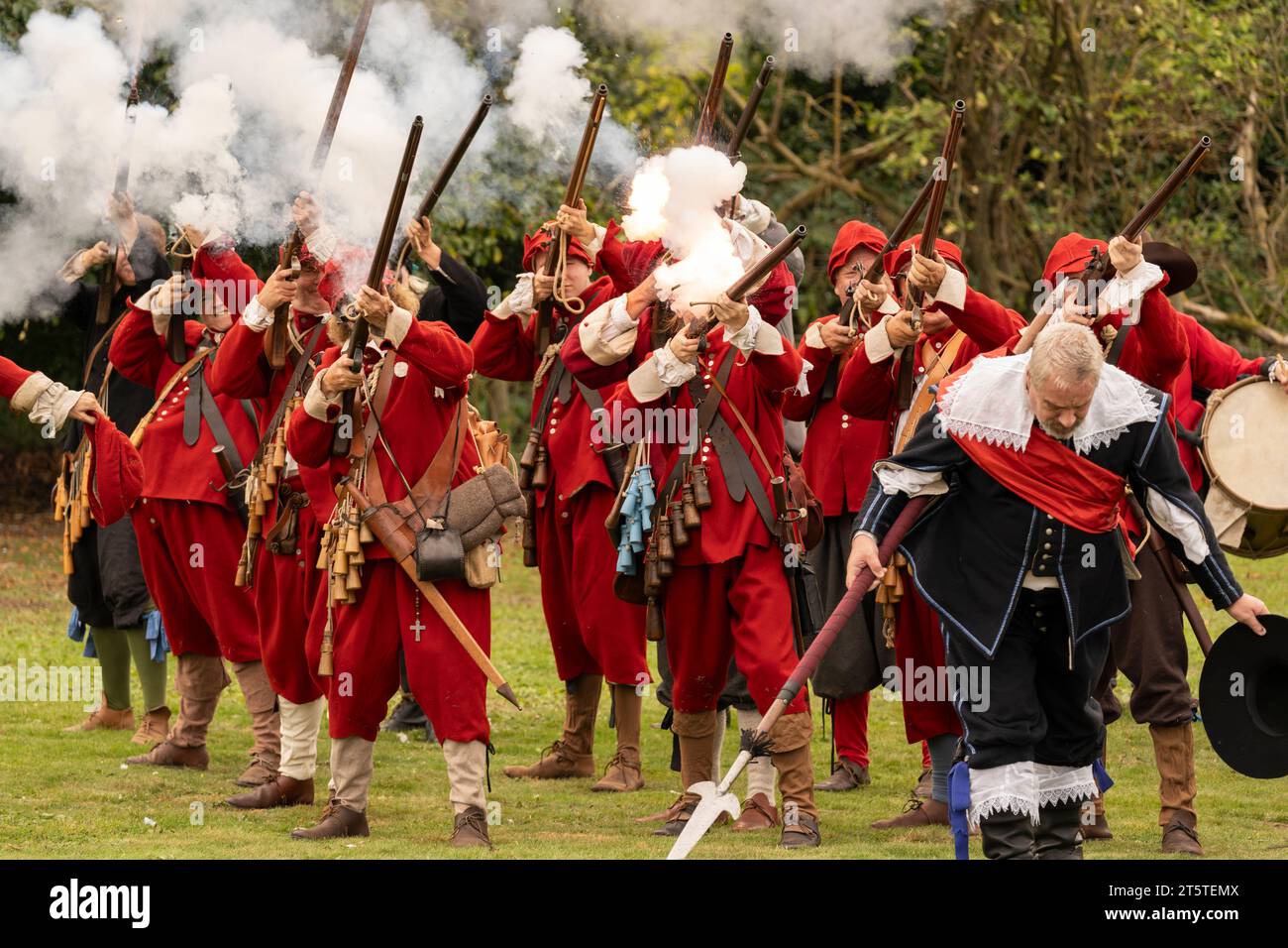 Musketeers firing a gun salute and company sergeant bowing after the end of the Siege of Basing House, civil war reenactment, Basingstoke, England Stock Photo