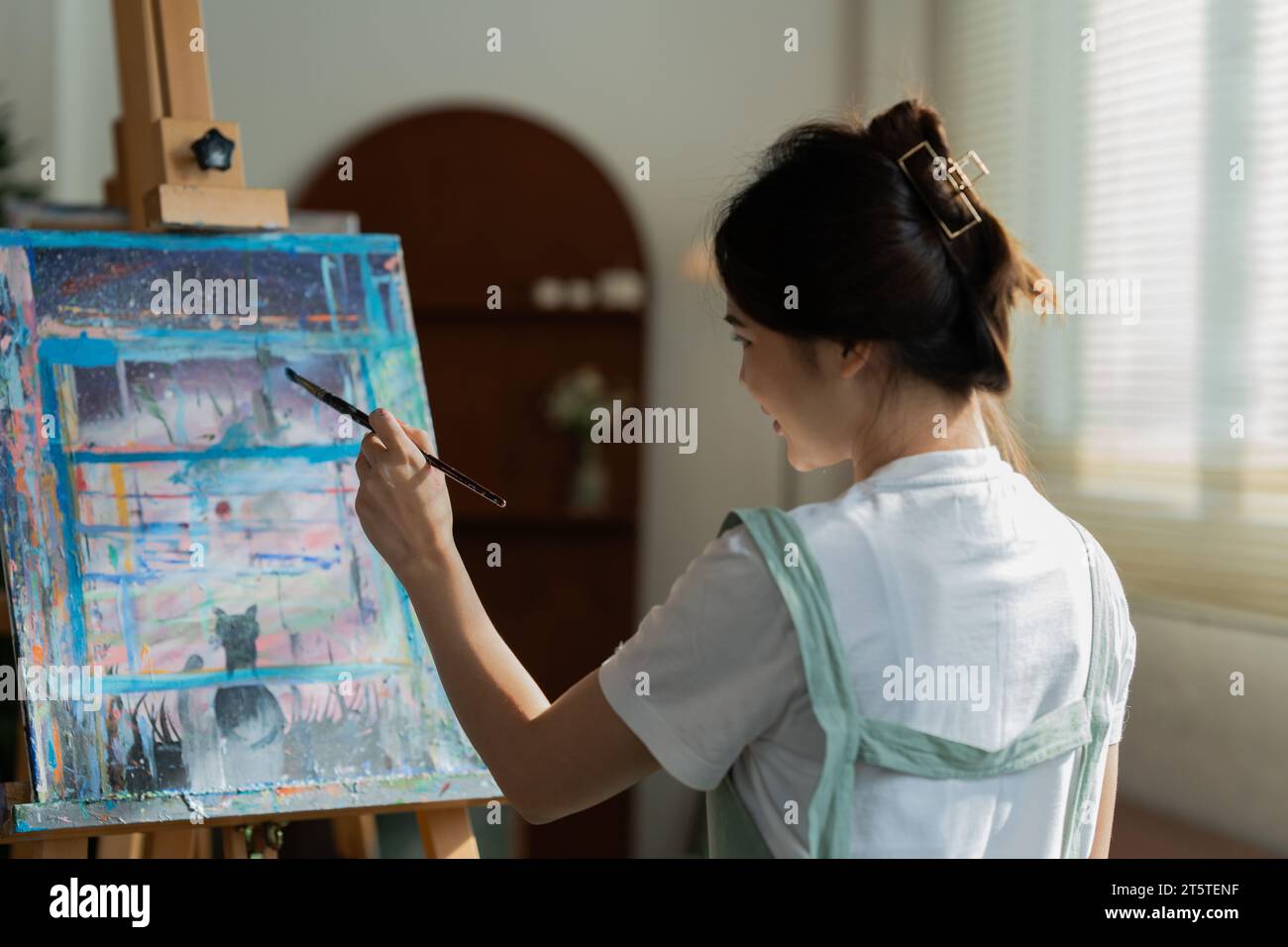 Female artist hold color palette and paintbrush for painting during ...