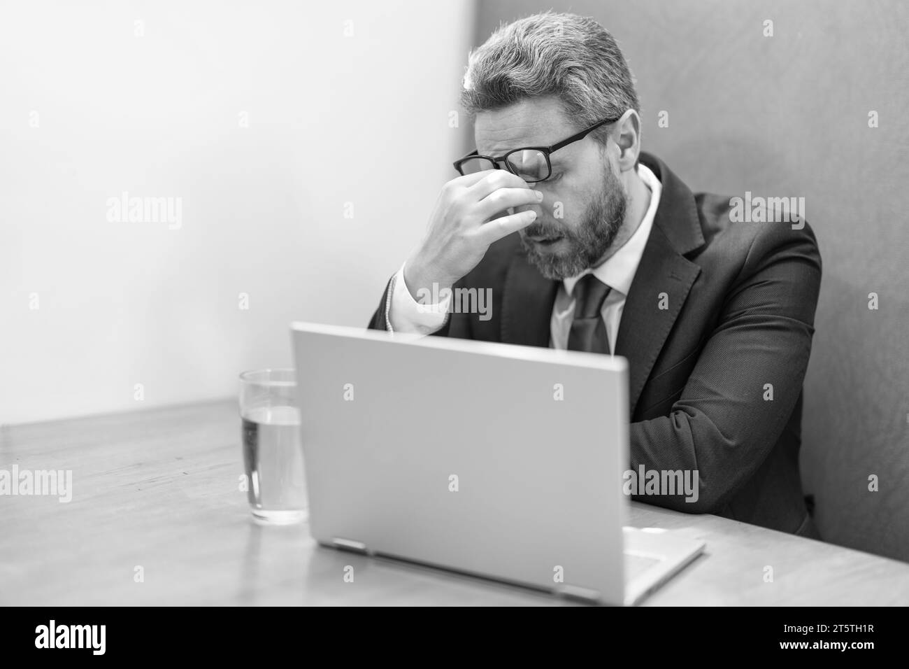 tired overworked businessman has headache while working. overworked