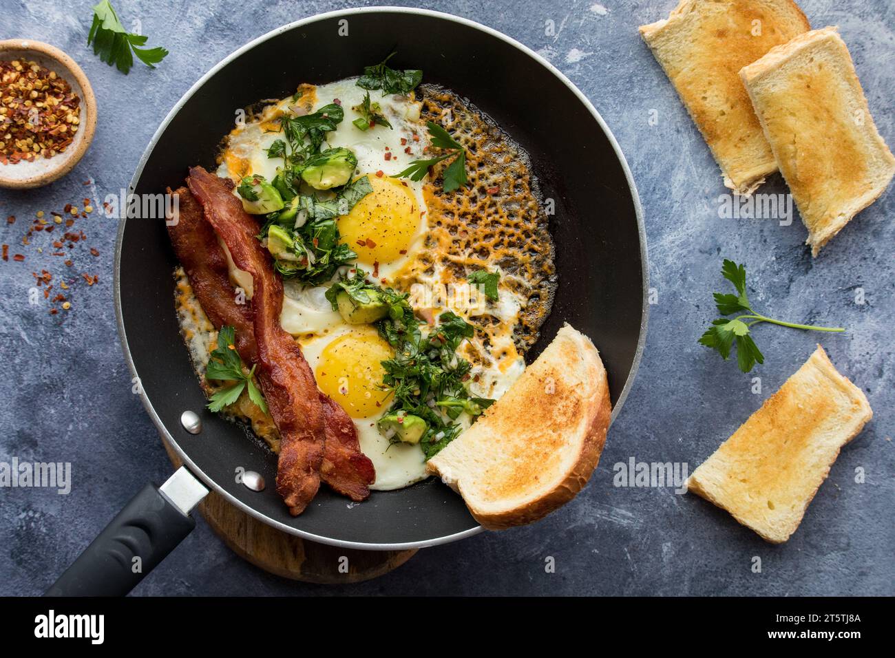 Cheddar cheese fried eggs, served with a garlic herb salad, bacon and
