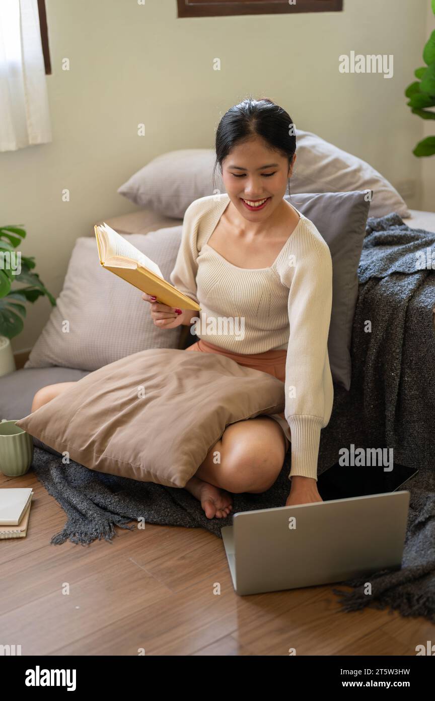 A beautiful and happy Asian woman is spending her free time in her ...