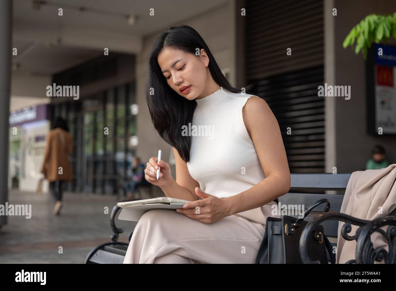 A beautiful millennial Asian businesswoman is focuses on her work ...