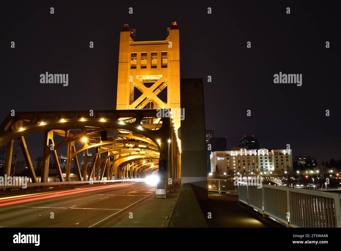 A bridge illuminated by street lights at night Stock Photo