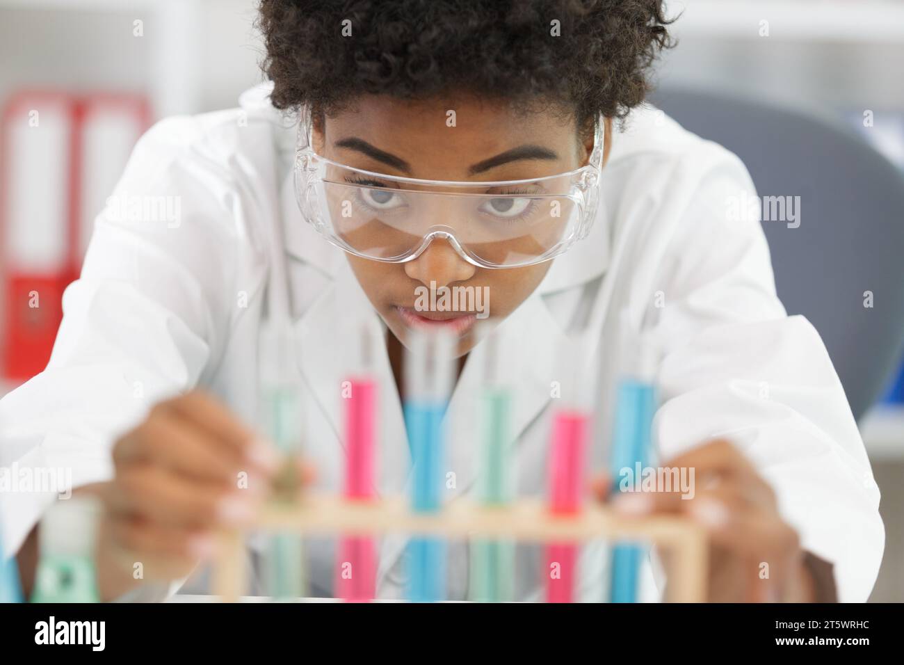 professional woman is pipetting solution into the glass Stock Photo