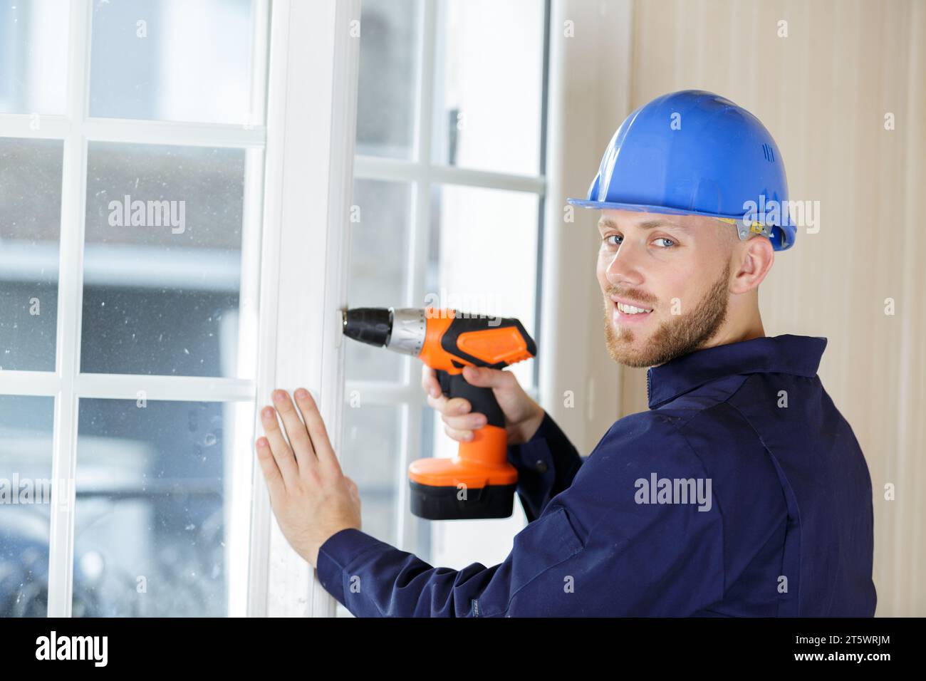 contractor using a cordless drill on a patio door Stock Photo