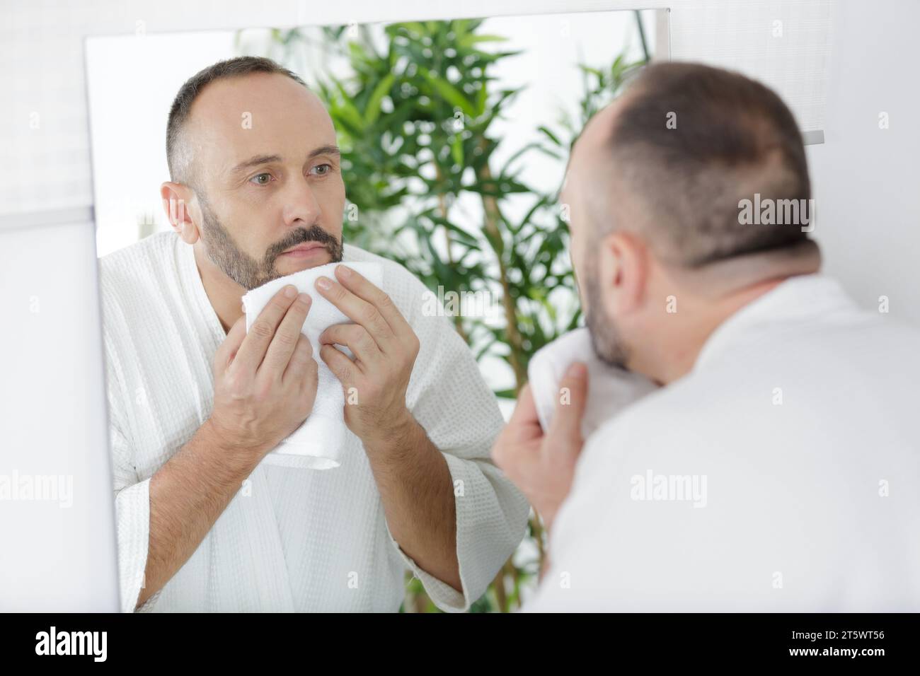 man touching his face after shaving Stock Photo Alamy