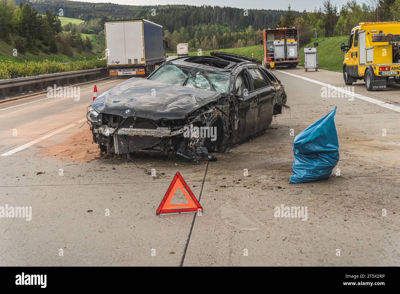 Aufnahme eines verunfallten PKWs der Marke BMW auf der A9.  Ein Warndreieck steht vor dem PKW, Trümmerteile des Unfalls wurden bereits in einem Müllsa Stock Photo