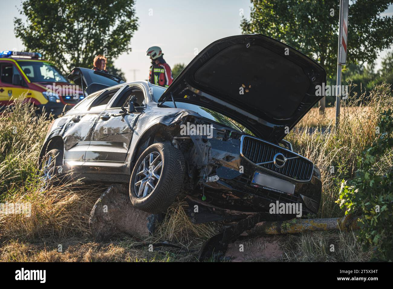 Ein verunfallter PKW der Marke Volvo liegt im Straßengraben, nachdem er mit einem Baum kollidiert ist.  14.07.2023 Stock Photo