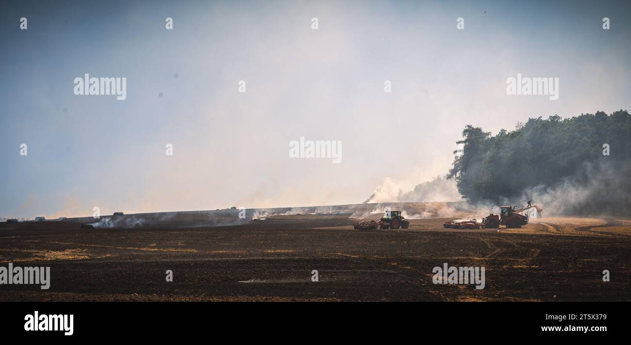 Bei einem Feldbrand nutzen die Landwirte ihre Traktoren um die Feuerwehr bei den Löscharbeiten zu unterstützen.  19.07.2022 Stock Photo
