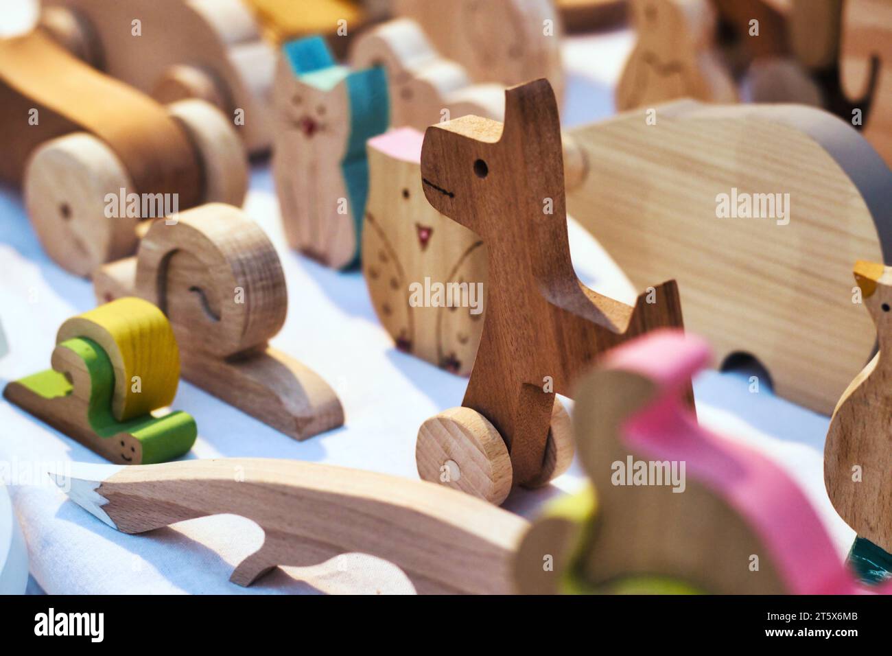 Handcarved wooden toys on display on a table at a craft fair Stock