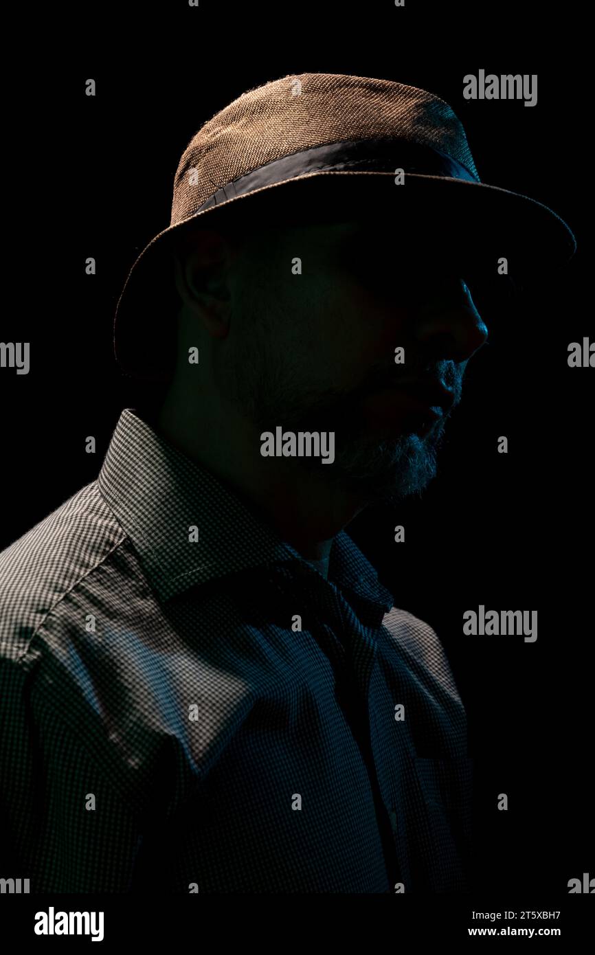 Mysterious man wearing hat and sunglasses. Portrait in dark studio ...
