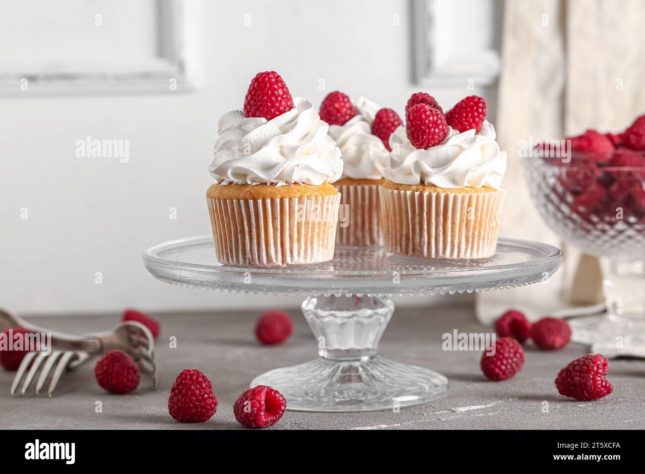 Stand with tasty raspberry cupcakes on table Stock Photo