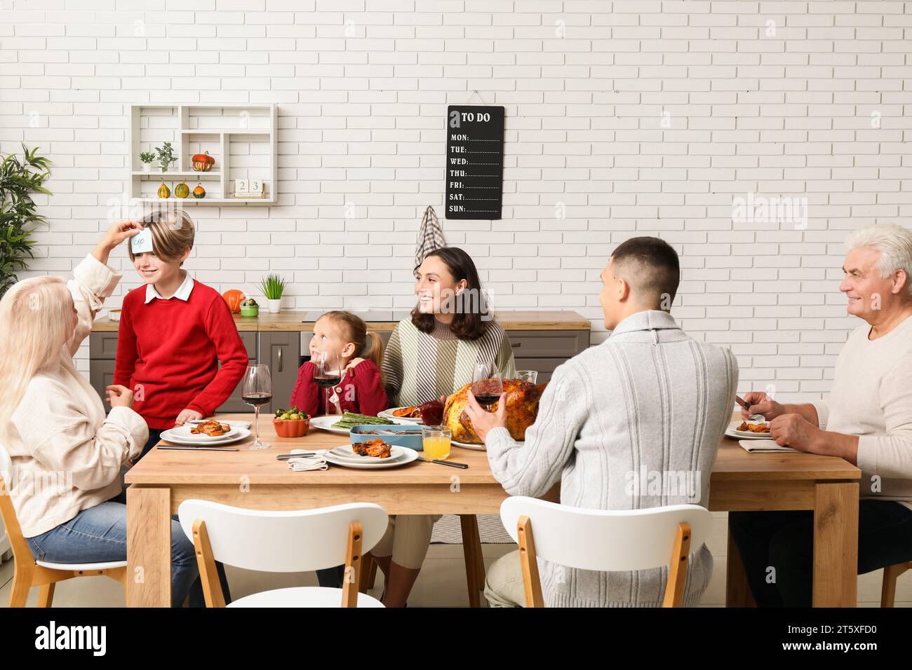 Happy family playing word guessing game at festive table on ...