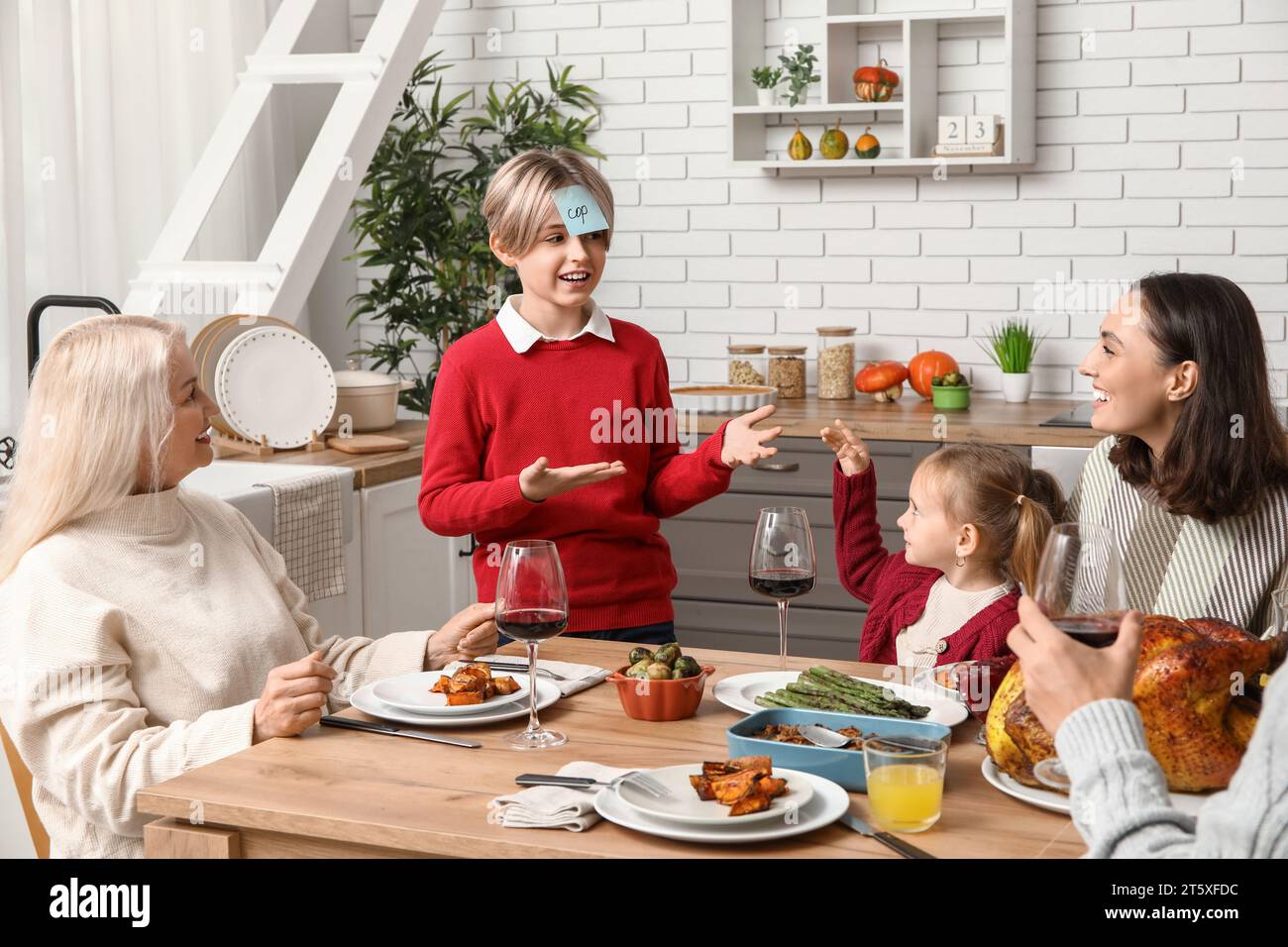 Happy family playing word guessing game at festive table on ...
