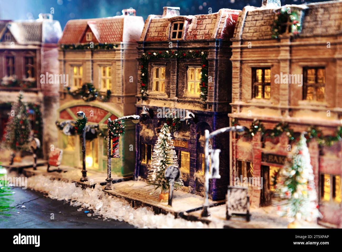 Night snow-covered European street decorated for Christmas. Homemade decorated toy houses. All elements of the image are made and drawn by hand. Stock Photo