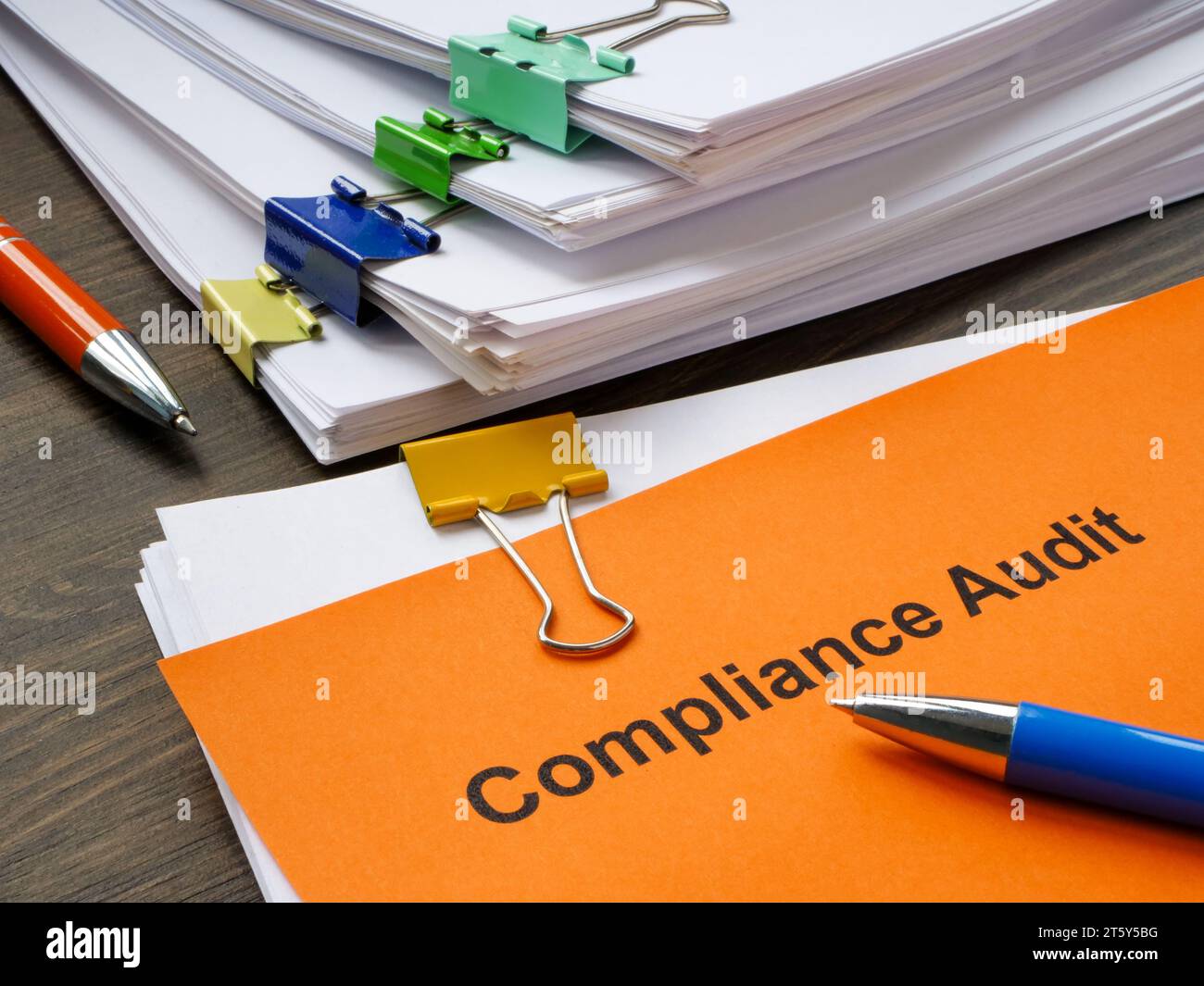Stack of paper and compliance audit report. Stock Photo