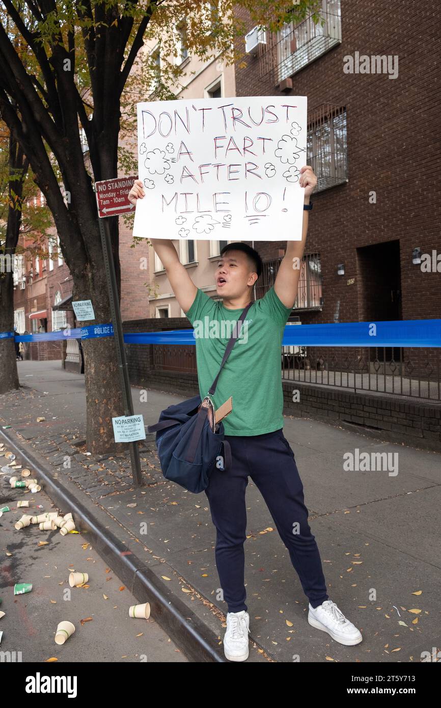 A spectator at the New York Marathon holds a sign with a fart joke. In Williamsburg, Brooklyn, New York Stock Photo