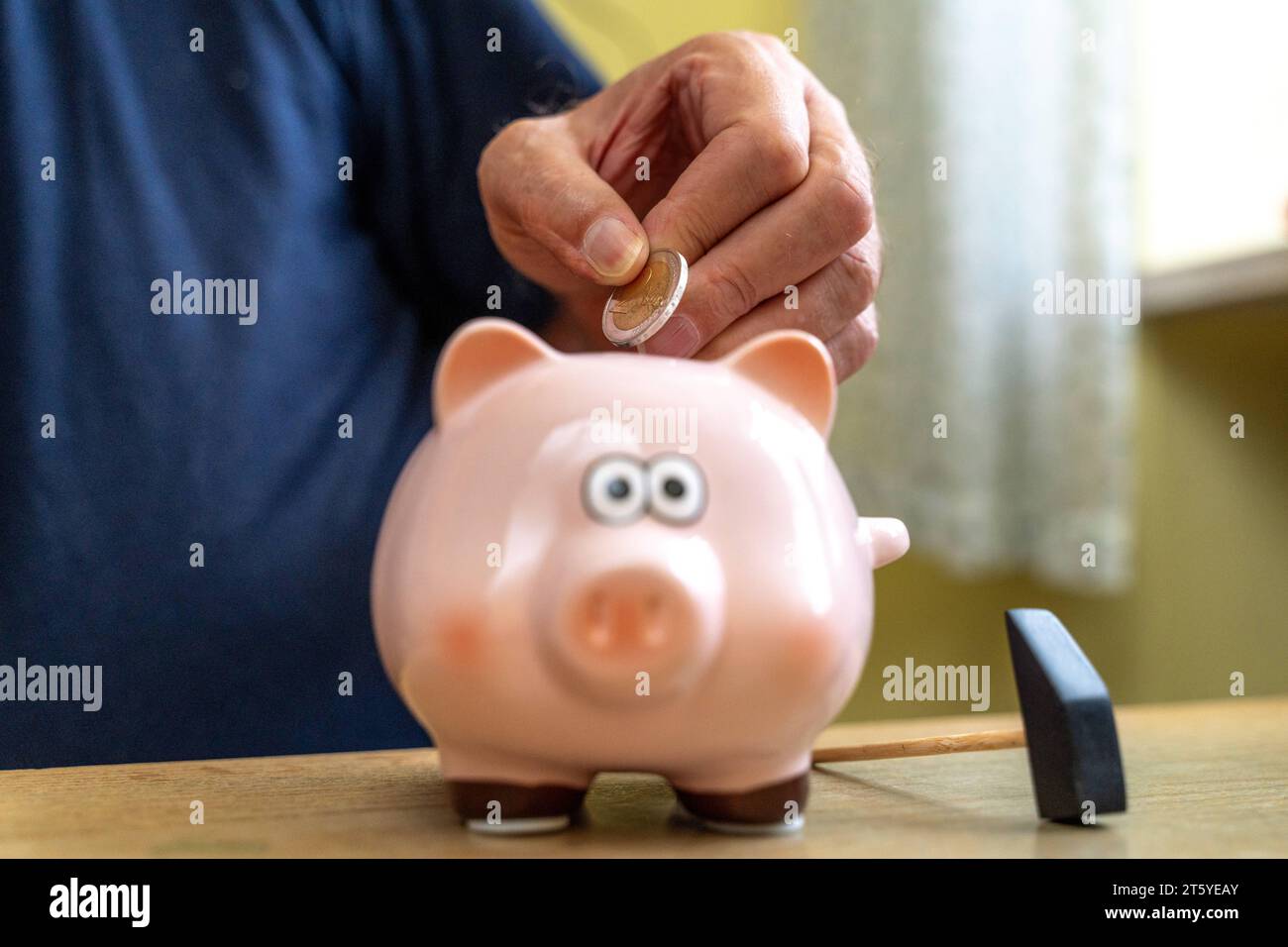 Augsburg, Bayern, Deutschland - 27 Oktober 2023: Ein alter Mann wirft Euro Geldmünzen in ein Sparschwein. Altersvorsorge Konzept *** An old man throws euro coins into a piggy bank. Retirement provision concept Credit: Imago/Alamy Live News Stock Photo