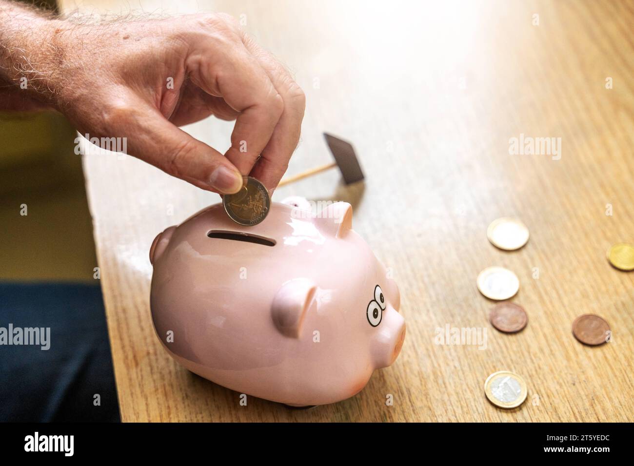 Augsburg, Bayern, Deutschland - 27 Oktober 2023: Ein alter Mann wirft Euro Geldmünzen in ein Sparschwein. Altersvorsorge Konzept *** An old man throws euro coins into a piggy bank. Retirement provision concept Credit: Imago/Alamy Live News Stock Photo