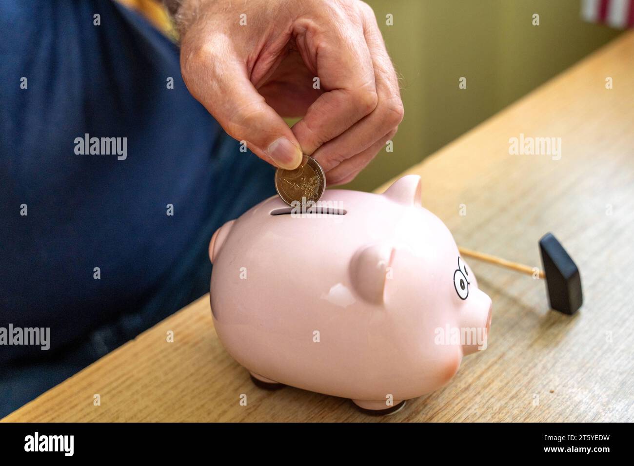 Augsburg, Bayern, Deutschland - 27 Oktober 2023: Ein alter Mann wirft Euro Geldmünzen in ein Sparschwein. Altersvorsorge Konzept *** An old man throws euro coins into a piggy bank. Retirement provision concept Credit: Imago/Alamy Live News Stock Photo