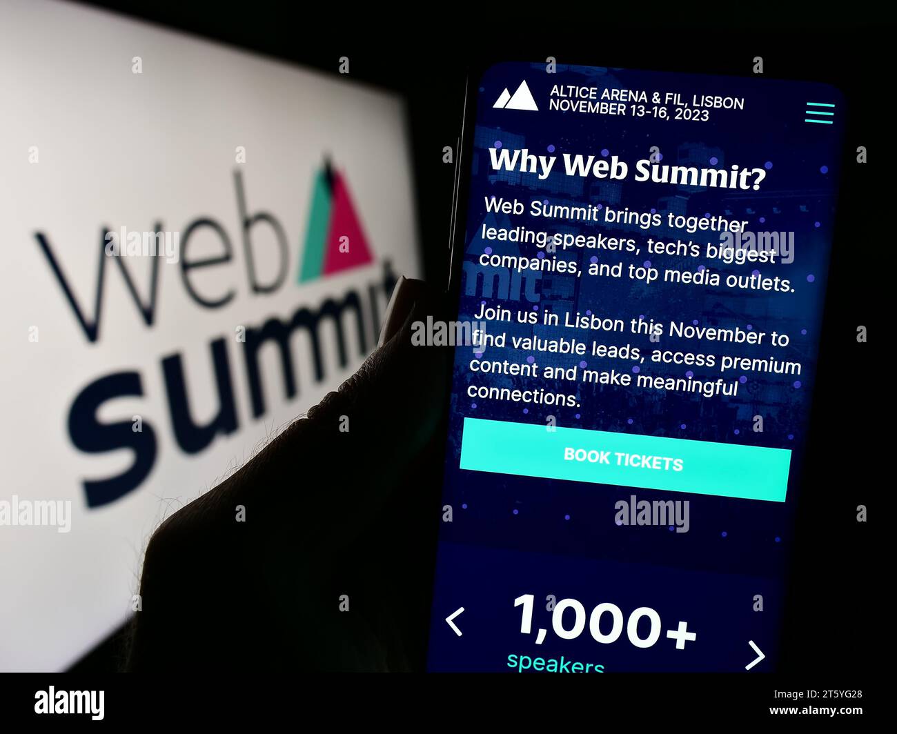 Person holding smartphone with webpage of annual technology conference Web Summit (Lisbon) in front of logo. Focus on center of phone display. Stock Photo